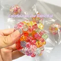Pelota antiestrés colorida de gemas sostenida en la mano con cuentas de arco iris - Pelota Ruidosa Cubos de Hielo Coloridos