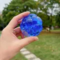 Nahaufnahme eines blauen, durchsichtigen Quetschspielzeugs zur Entspannung im Freien - Saphirblau Quetschen