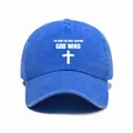 Detailed view of white cross and religious text print on blue washed denim cap - One Size / Blue