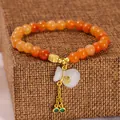 Bracelet en perles d'aventurine rouge avec breloque sac de fortune en jade et chaîne dorée. - 6mm / Style Sac de Chance Aventurine Rouge Naturelle