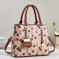 Sac à main élégant pour femme avec imprimé cerises, anses marron et petit charme - Abricot
