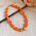 Macro shot of retro orange acrylic beaded necklace with gold textured focal bead - 61# Necklace / Orange