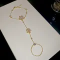 Detail of 14k gold plated bracelet ring combo with sparkling zircon flower charms. - Clear Zirconia Style / Gold