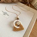 Detail view of a handcrafted rattan triangle pendant with a white ring and flower. - Style 1# (Triangle Ring Overlay) / Beige and Coffee