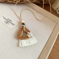 Detailed macro shot of a handmade woven rattan necklace with white tassel skirt pendant. - Style 4# (Triangle Skirt Tassel) / Beige and Coffee