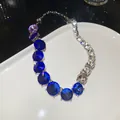 Elegante Halskette mit blauen Kristallverläufen auf einem luxuriösen weißen Porzellanteller - Nur Kette / Silber-Lila-Blau