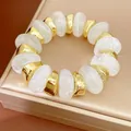 Detail van witte gemarmerde acryl en gouden onregelmatige kralen elastische armband - Helder Wit