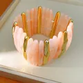 Macro detail showing the marbled texture of peach acrylic and gold-tone metal bracelet links - Pink