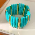 Close-up detail of a turquoise marbled acrylic and gold-tone segment stretch bracelet - Green