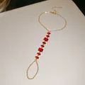 Vue macro montrant la chaîne dorée complexe et les pierres de zircon rouges du bracelet - Rond Rouge / Or