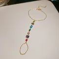 Détail en gros plan du bracelet-bague intégré doré avec des zircons géométriques - Multicolore Rond Carré Mixte / Or