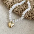Dettaglio ravvicinato delle perle acriliche marmorizzate bianche e ciondolo a cuore - Collana / Trasparente