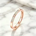 Vista de detalle de un anillo de acero inoxidable de oro rosa con ocho circonitas pavé. - Talla 5 / Estilo Pavé Grabado / Rosa oro