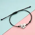 Detailed view of stainless steel heart charm with cut-out letter A on braided cord - Letter A / Steel Color Black Rope