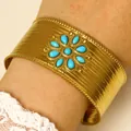 Wide gold-toned cuff bracelet featuring vibrant blue turquoise stones in a floral pattern. - Turquoise Flower Style (K-1473) / Gold