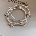 Detailaufnahme von drei silbernen Metallarmbändern mit kleinen Kugel-Cluster-Anhängern - Silberne Spiraltextur Armreif Kombination (38) / Dreiteiliges Set / Silber