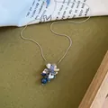 Detailweergave van zilverkleurige bloemenketting met elegante blauwe druifvormige kralen. - Metalen Bloemblaadjes Blauwe Kralen-Zilver-Blauw
