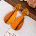 Élégantes boucles d'oreilles goutte en résine ambre marbré avec clous en argent - Larme / Orange