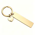 Close-up of golden stainless steel keychain with rectangle bar and heart charm - Gold