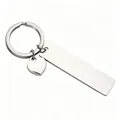 Macro detail showing the polished mirror finish of the stainless steel bar and heart charm keychain - Steel