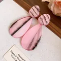 Gros plan de boucles d'oreilles élégantes en résine rose en forme de goutte marbrée - Larme / Rose
