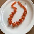 Vibrant orange acrylic beaded necklace with faceted charms and elegant gold spacers - Orange
