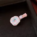 Makroaufnahme einer handgefertigten Donut-Haarklammer mit Herzzirkon und pinkfarbenen Steinen - Rosa