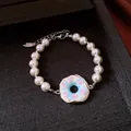 Elegantes Perlenarmband mit einem farbenfrohen blauen und rosa Donut-Anhänger mit Kristallen - Armband / Silber Weiß Rosa