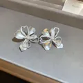 Minimalistische zilveren oorknopjes met gestileerde bloemblaadjes en geometrische hartdetails - Matte Holle Bloemblaadjes (10#)