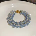 Close-up of handmade woven bracelet with light blue glass beads and white pearls - Style 79 Bracelet / Gold-Sky Blue