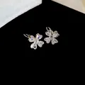 Détail de boucles d'oreilles trèfle en argent avec zircons en forme de cœur brillants. - Boucles d'Oreilles Créoles (Argent)