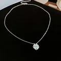 Détail d'un pendentif trèfle à quatre feuilles bleu clair sur une chaîne de couleur argentée - Collier (Argent-Bleu)