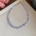 Close-up of elegant iridescent glass beaded necklace with gold-tone extension chain - Necklace / Blue