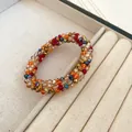 Exquisite close-up detail of a multi-colored faceted crystal beaded bracelet on a tray - 75# Bracelet / Red-Orange