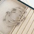 Close-up of silver-tone textured bangles with delicate bead charms in a jewelry box - Three-Piece Set / 55# Bangle Silver