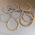 Collectie stijlvolle gouden en zilveren metalen open armbanden met diverse texturen. - Multi-stijl Collectie / Multicolor Combo