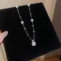 Detailansicht einer eleganten Perlenkette mit funkelndem quadratischem Zirkonia-Anhänger auf Samt - 66# Halskette Quadratischer Großer Zirkonia Perle