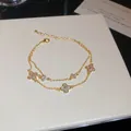 Detalle de una pulsera de doble capa chapada en oro de 14k con tréboles de la suerte - Estilo de Doble Capa de Trébol / Dorado