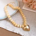Detailed view of the creamy resin beads and high-polish gold heart pendant on necklace - Heart Pendant Beaded Necklace (59#) / Gold + Khaki (59#)