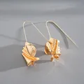 Detailed view of gold-finished earrings featuring a unique crumpled metal leaf design - Ear Hook Style / Gold