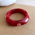 Detailopname van een rode kunsthars armband met marmertextuur en edelsteenversiering - Rood