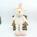 Peluche mouton vintage aux longues jambes bouclées avec haut-de-forme rose sur un banc. - Mouton Rose