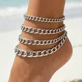 Silver multi-layered Cuban link anklets for women shown on foot with beach background - Silver Cuban Chain Set (32761-ank-S-EP)