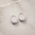 Élégantes boucles d'oreilles créoles irrégulières en argent sur fond de marbre blanc - Croissant Irrégulier Argent (E8539)