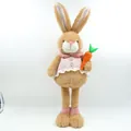 Staand pluche paashaasfiguur met een roze geruit pakje en een wortel in de hand - Groene Outfit Paaspop