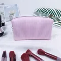 Detail shot of pink seersucker striped travel cosmetic bag in a lifestyle setting context - Pink