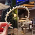 Elegante dunne gouden hoofdband versierd met glanzende witte parels in diverse maten - Kleine driehoek imitatieparel stijl