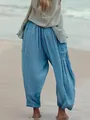 Detail of the textured fabric on women's blue pleated cotton linen cropped pants on beach - Light Blue Striped