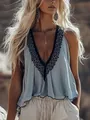 Dettaglio di una canotta azzurra senza maniche con scollo a V e pizzo nero. - S / Blu