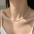 Vue détaillée d'un élégant collier ras du cou en perles d'eau douce sur un mannequin. - Collier de perles de riz d'eau douce naturelles (4 mm)